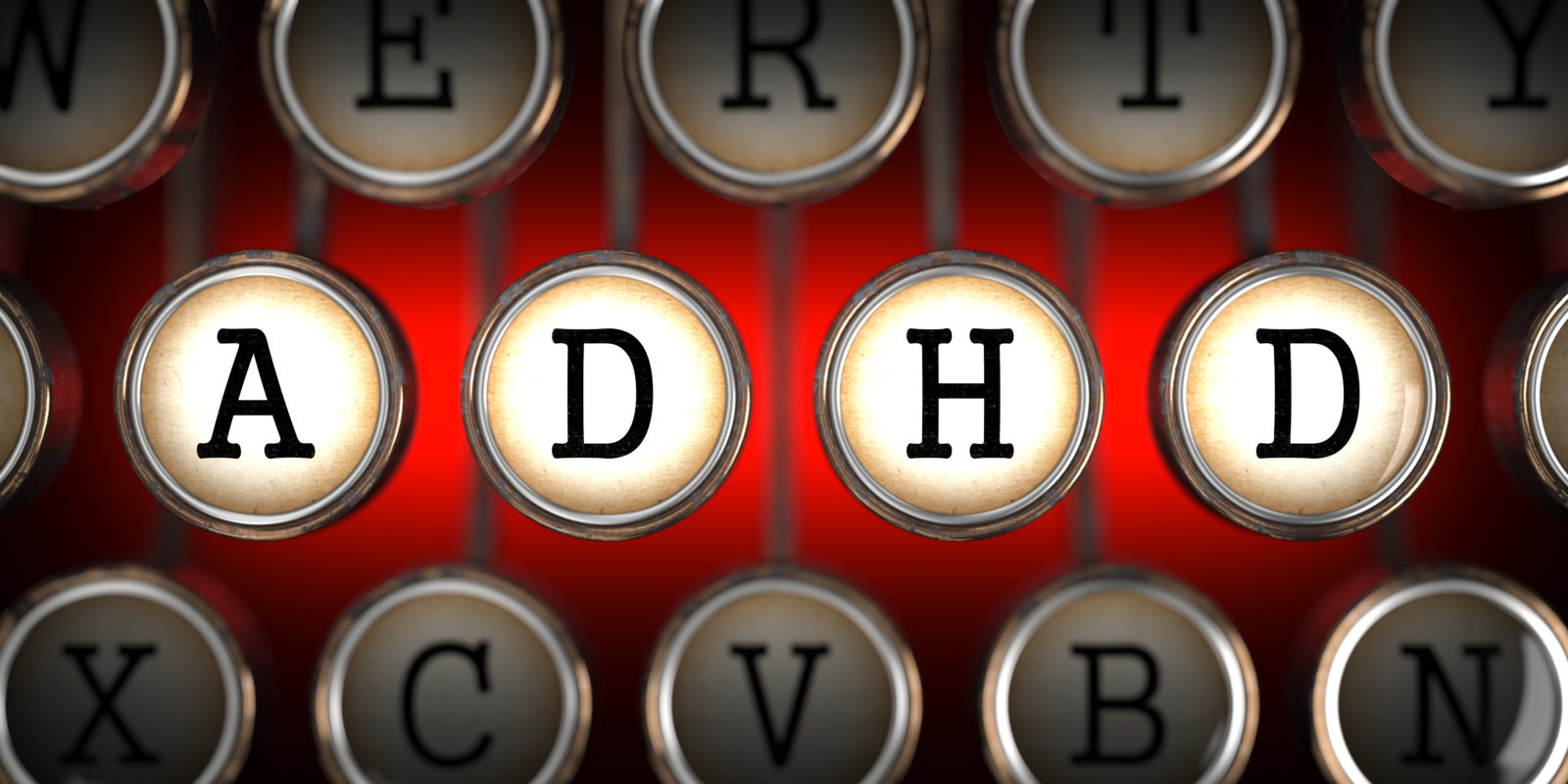 ADHD on Old Typewriter's Keys on Red Background.