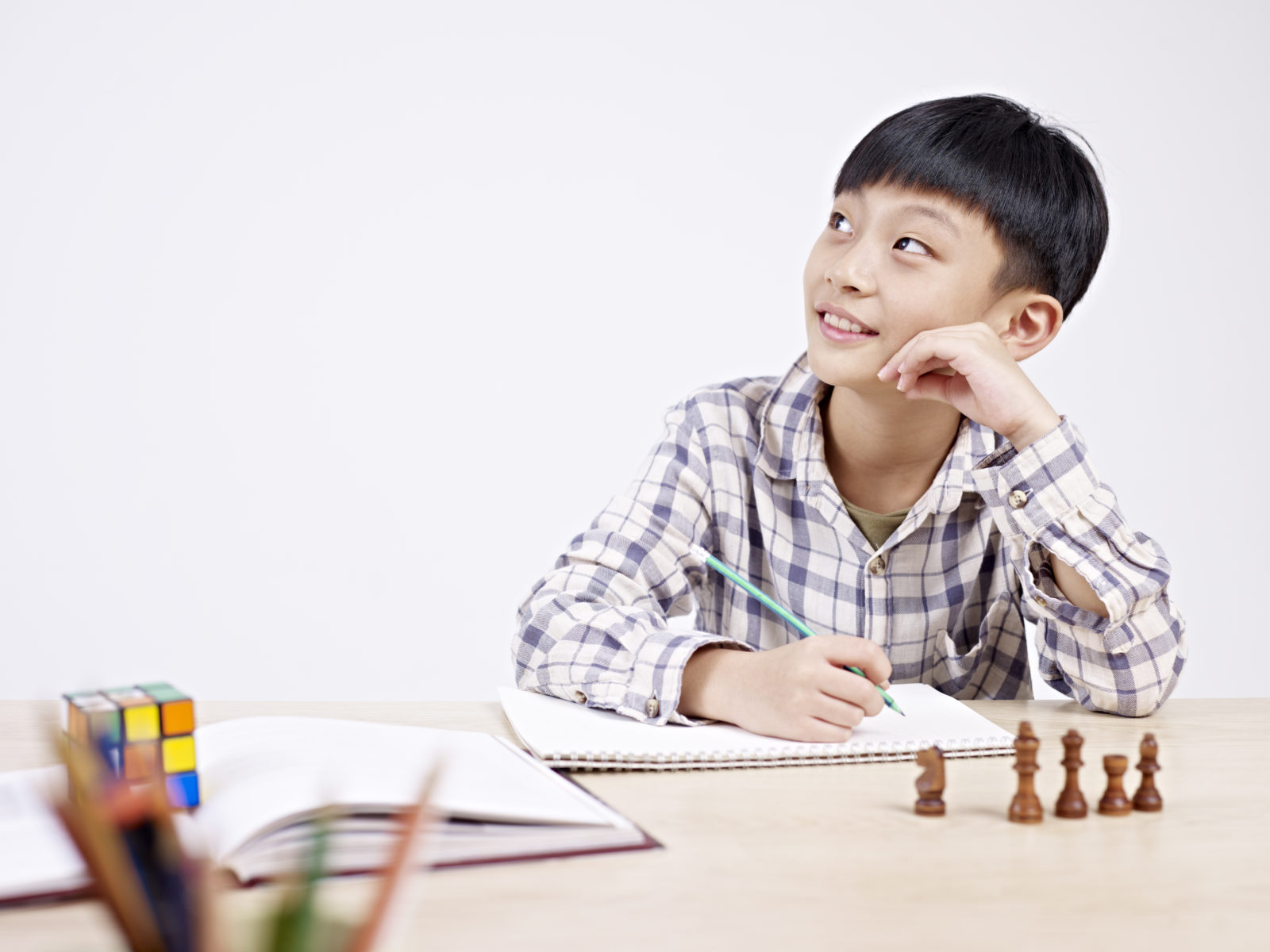 10 year-old asian elementary schoolboy looking away while studying.